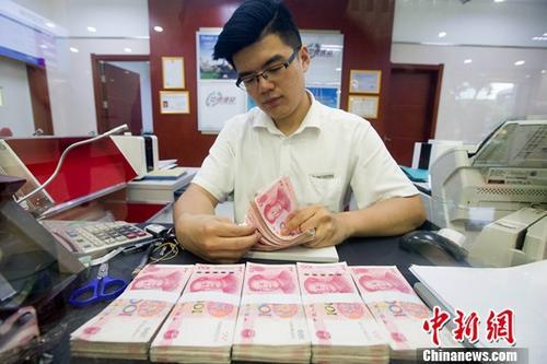 质料图：山西太原一银行工作人员正在清点货币。中新社记者 张云 摄